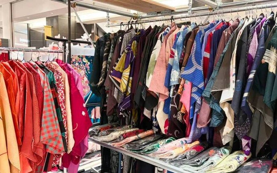 A rack of variously patterned scarves and folded fabrics. 2