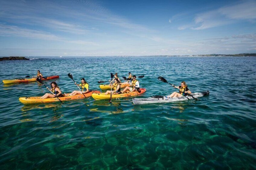 A group of people kayaking on clear blue water. 5