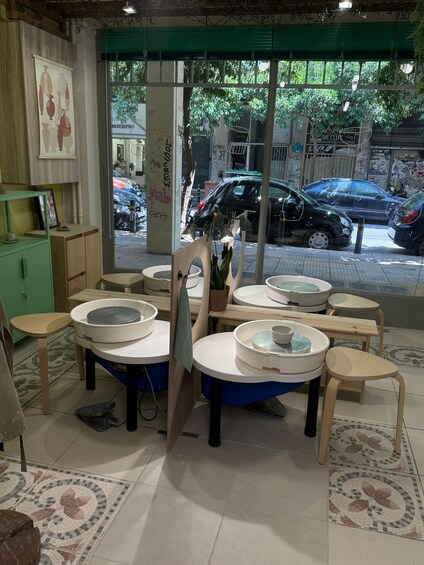 A cafe interior with round tables, chairs, and a tiled floor. 2