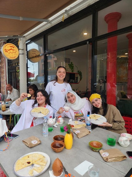 A group of people dining at a restaurant with various dishes and drinks on the table. 2