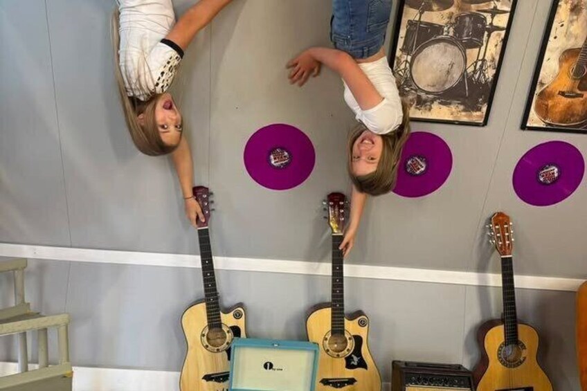 A person lying on the floor with guitars and a drum set. 4