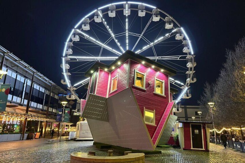 A Ferris wheel, a pink house, and a building with a sloped roof. 1