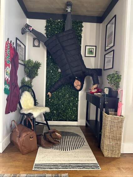 A person hanging upside down in a doorway. 4