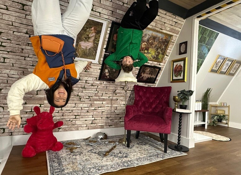 A room with a brick wall, a red plush toy, a red chair, and various framed pictures. 2