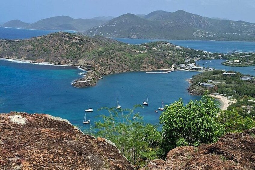 A coastal landscape with boats, rocky terrain, and distant mountains. 3