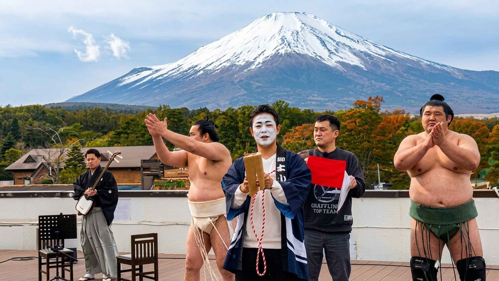 A group of people on a rooftop with a snow-capped mountain in the background. 3