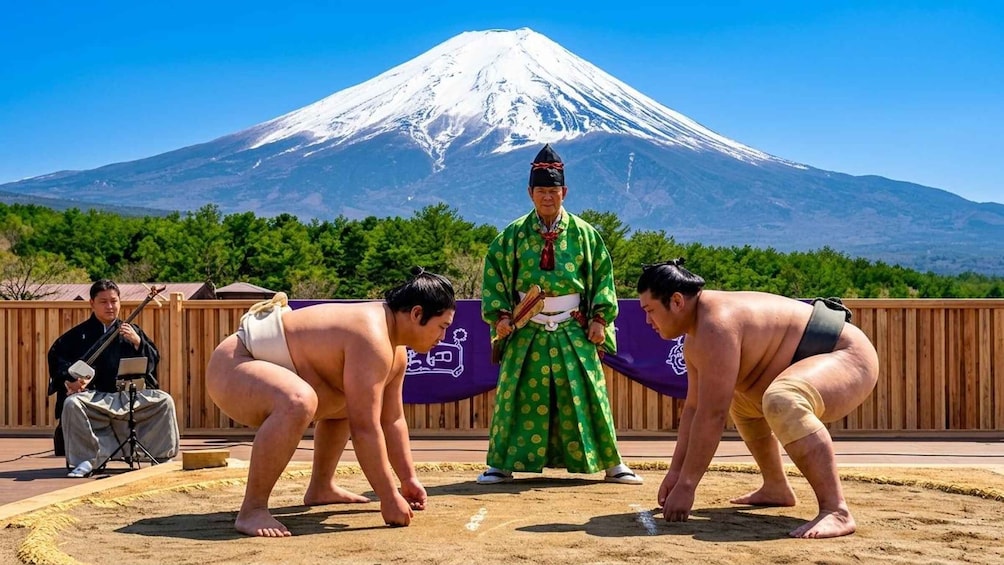 A sumo wrestling match with a backdrop of Mount Fuji. 1