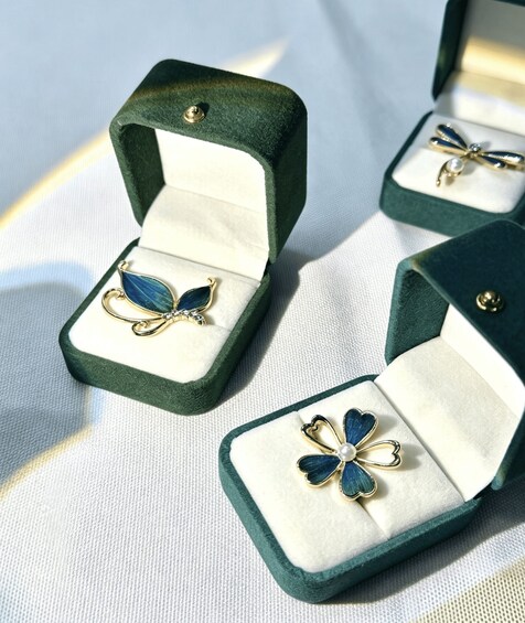 Three open jewelry boxes with butterfly-shaped earrings. 3