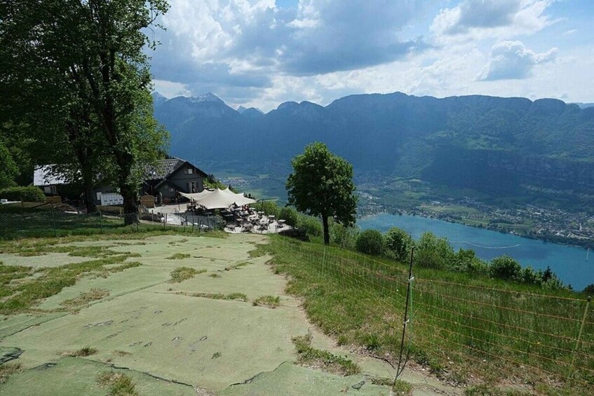 A house with a mountain backdrop, a lake, and a clear sky. 1