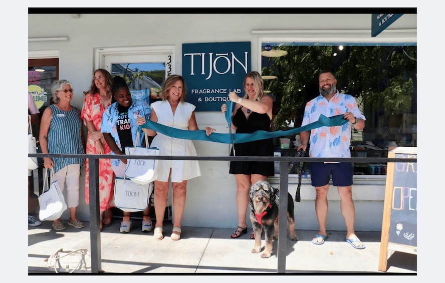 A group of people cutting a ribbon at the opening of a Tijon fragrance lab and boutique. 4