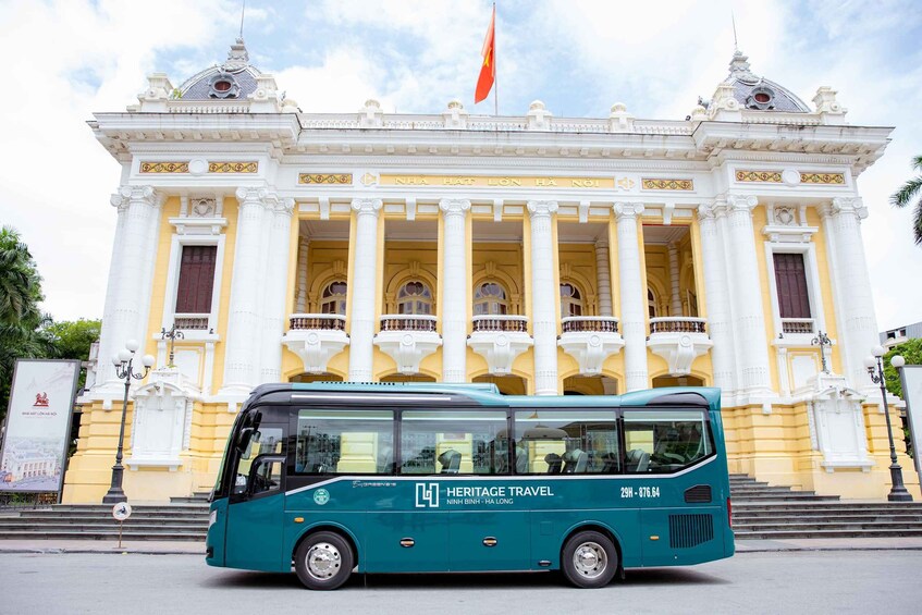 A heritage travel bus in front of a grand building with columns and a flag. 5