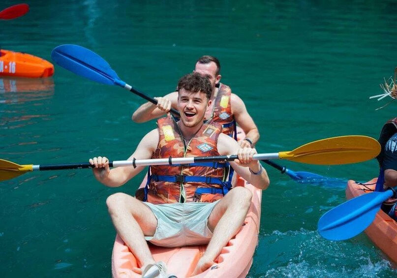 A person in a kayak with a life jacket, paddling on a body of water. 3