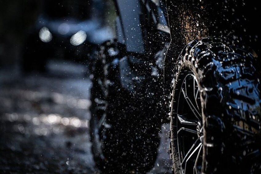 A close-up of a car's wheel and tire in motion, splashing water. 3