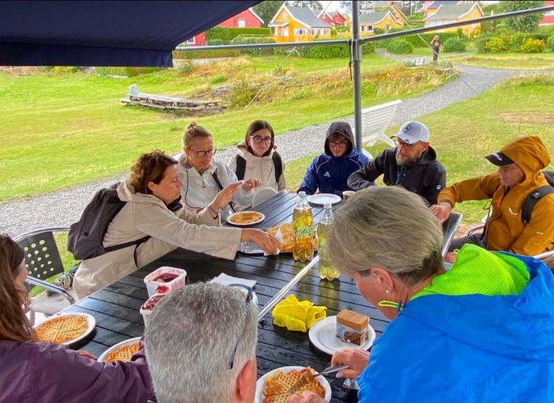 A group of people dining outdoors at a table with waffles and drinks. 4