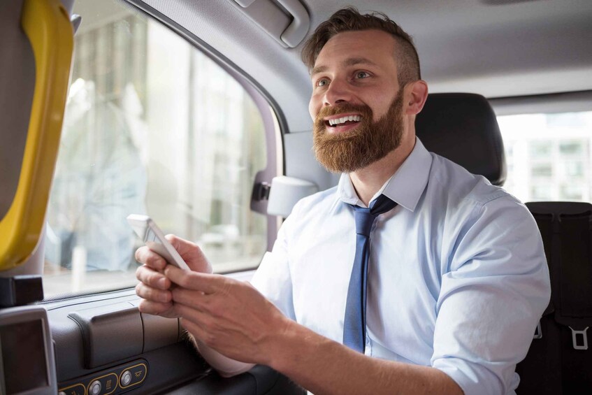 A person in a car holding a mobile device. 5