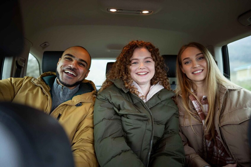 Three people sitting in a car. 3