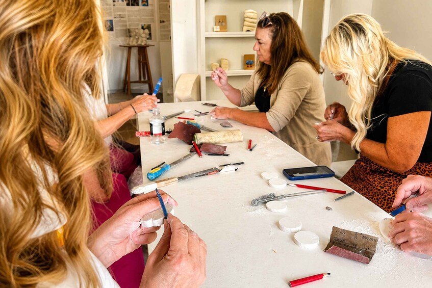 A group of people engaged in a crafting activity with various tools and materials on a table. 2
