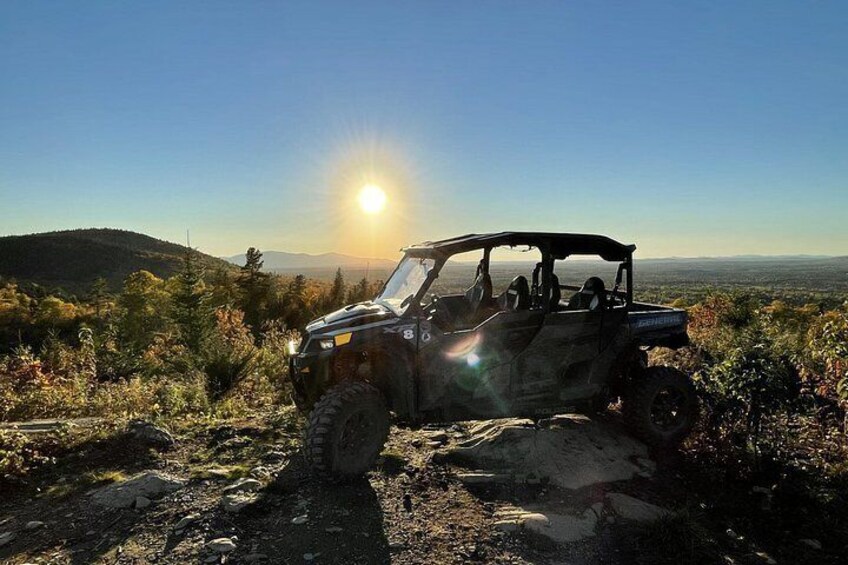A 4x4 vehicle on a rocky trail with a sunset in the background. 2