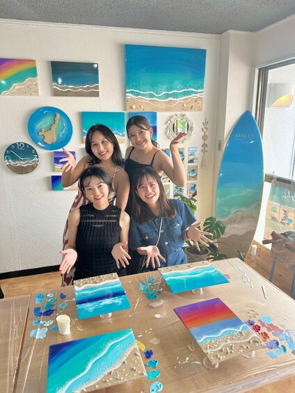 A group of people in a room with various artworks and a surfboard. 5