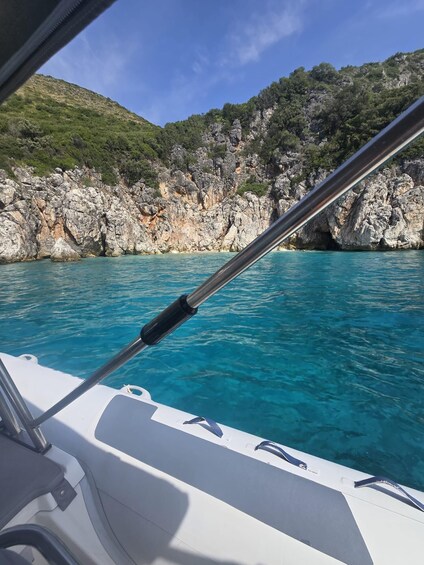 A boat's interior with a view of clear blue water and rocky cliffs. 2