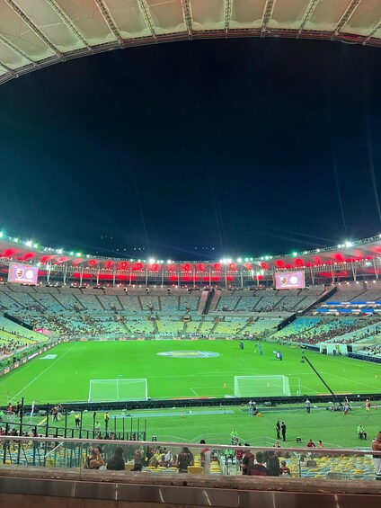 A large, empty stadium at night with bright lights and a green field. 5