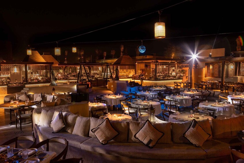An indoor restaurant with multiple dining tables and a sofa area. 1