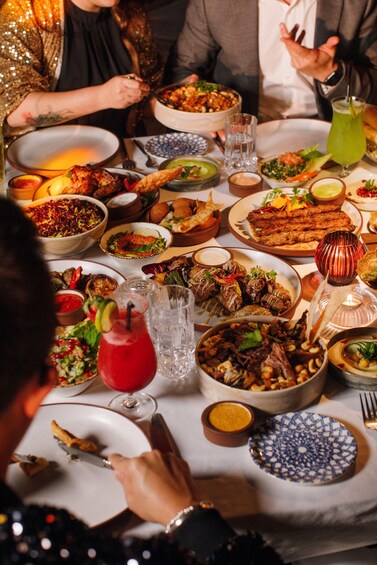A table with various dishes, drinks, and a candle. 2