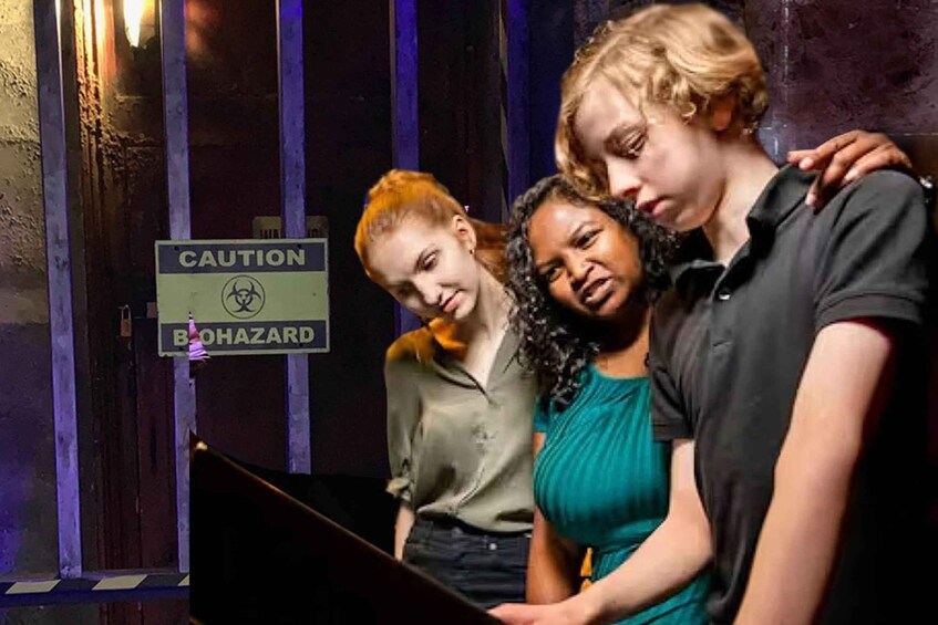Three people standing in front of a caution biohazard sign. 1