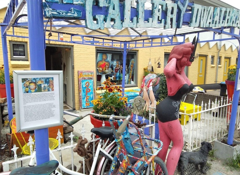 A colorful outdoor art installation with a large sculpture of a woman, a bicycle, and a dog. 3