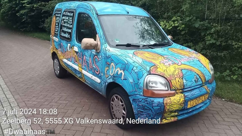 A colorful van parked on a paved path with trees in the background. 1