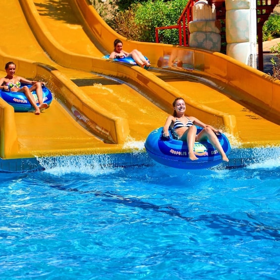 A water slide with people in inflatable tubes. 1