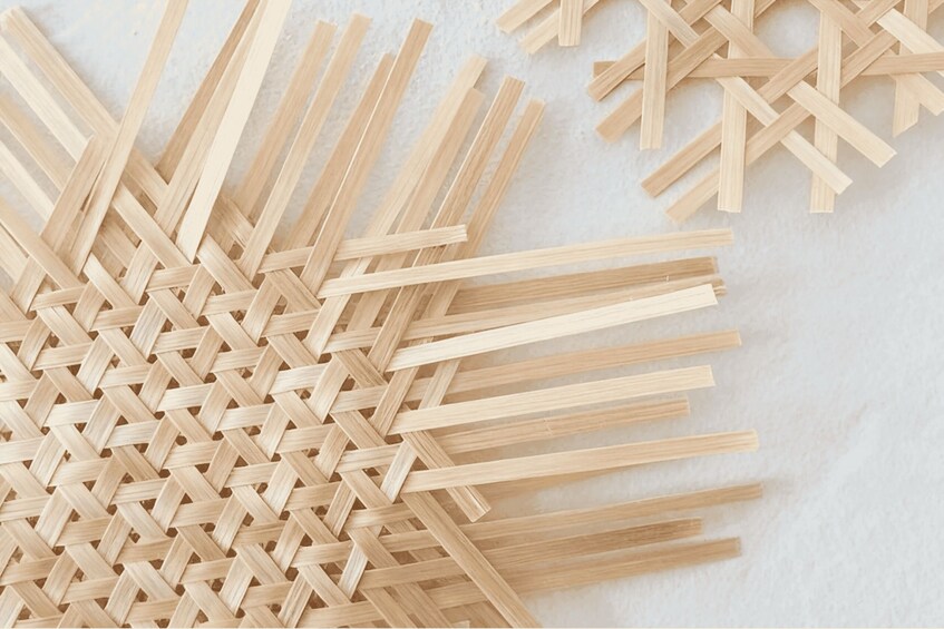 A collection of wooden sticks arranged in a crisscross pattern on a textured surface. 3