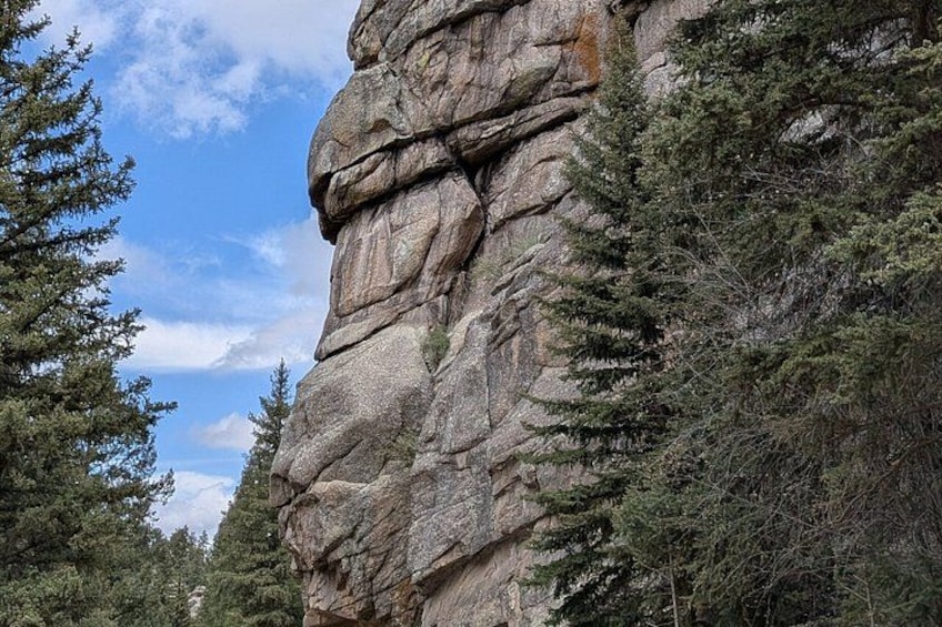 A large rock formation surrounded by trees. 2