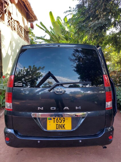 Un Toyota Land Cruiser negro estacionado frente a una casa con techo de paja. 5