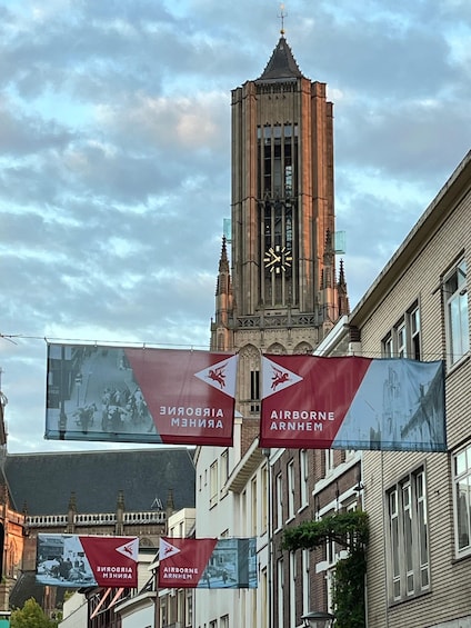 A historic clock tower with banners advertising Airborne Arnhem. 3