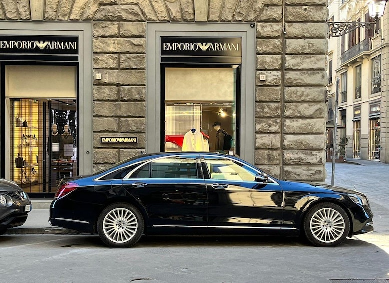 A black car parked in front of an Emporio Armani store. 3