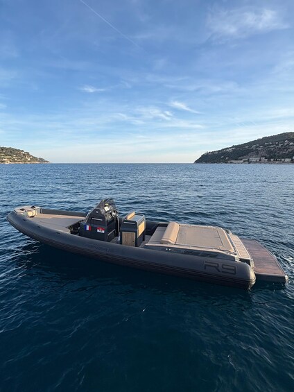 A motorboat on calm water with a clear sky and distant hills. 4