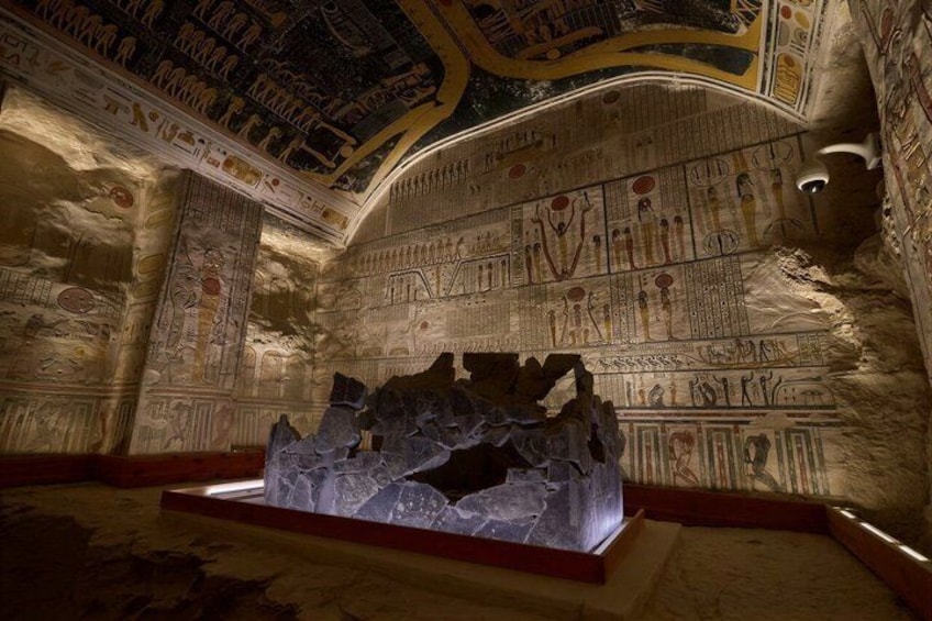 An ancient Egyptian tomb with hieroglyphs on the walls and a sarcophagus. 5