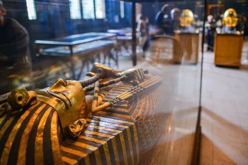 An ancient Egyptian sarcophagus with hieroglyphics and a golden cobra head. 1