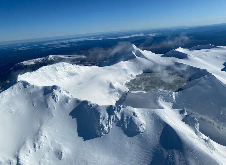 A vast snow-covered mountain range with clear skies. 1
