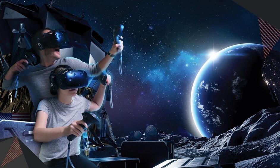Two people using virtual reality headsets with a space-themed background. 1