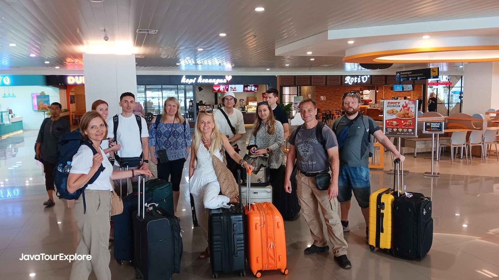 A group of people with luggage in an airport terminal. 1
