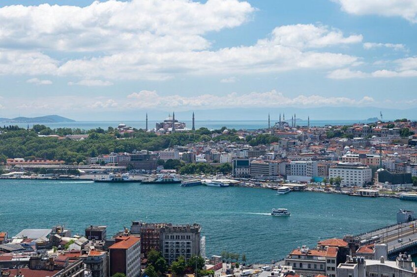 A coastal cityscape with a harbor, buildings, and a distant mountain range. 5