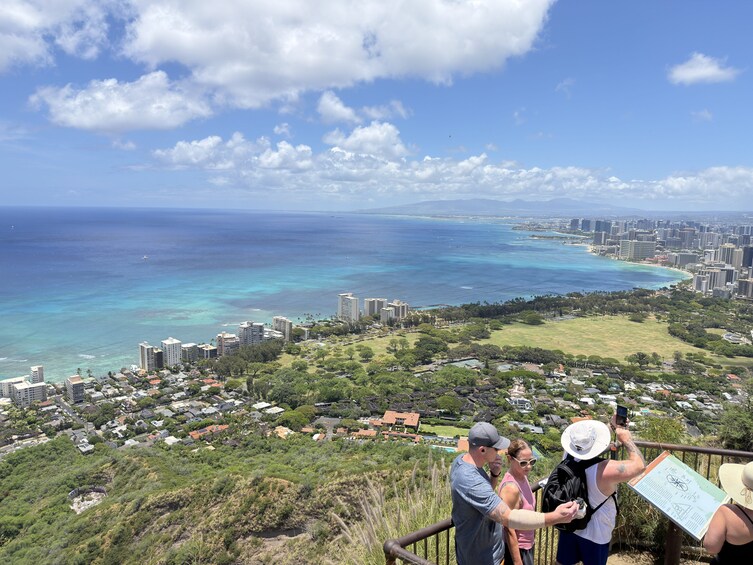 A coastal cityscape with a view of the ocean, buildings, and a grassy area. 2