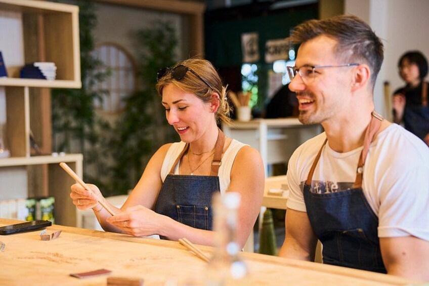 Two people in aprons working at a wooden table with cooking utensils. 5