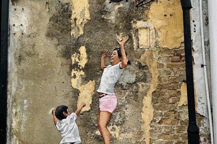 A person climbing a weathered wall with peeling paint. 4