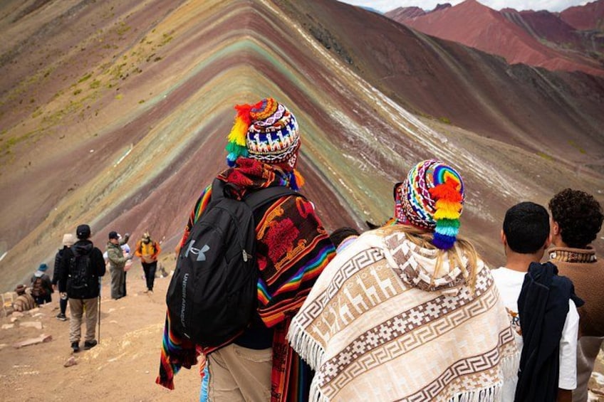 People hiking on a mountain trail with colorful traditional attire. 3