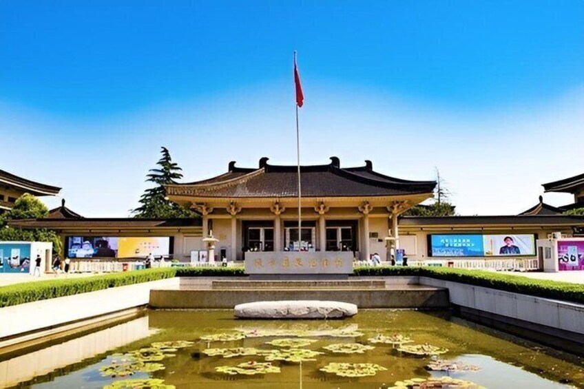 A traditional building with a flagpole, surrounded by a pond with lily pads. 1