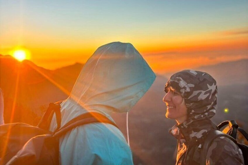 Two people hiking with a sunset in the background. 4