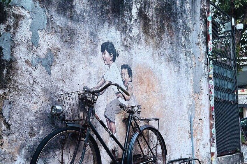 A mural of a person riding a bicycle on a textured wall. 4